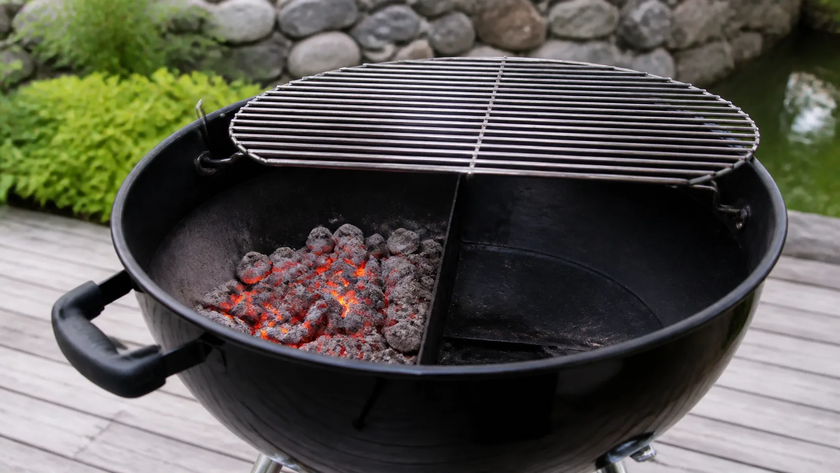 Kol placerat på ena sidan av en grill för direkt och indirekt värme.