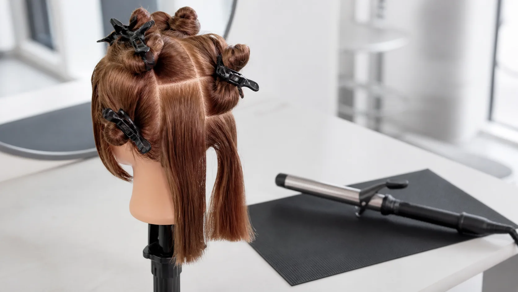 Hår delas i jämna sektioner före styling med locktång.